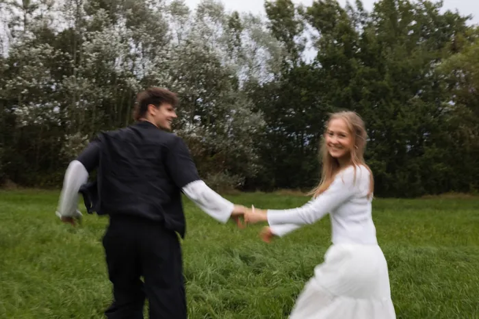 Elias und Magdalena laufen Hand in Hand über die Wiese